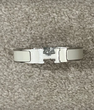 H-armband snygg detalj till outfiten -  Snyggt H armband som har silvriga och vita detaljer som kommer fräscha upp din outfit och göra den extra snygg och stilig 