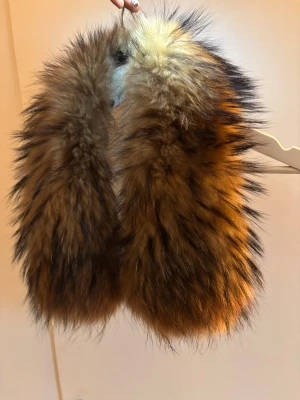 HOLLIES | Brun fluffig pälskrage  - Säljer en pälskrage från min HOLLIES jacka. Den är i väldigt fint skick och går att sätta på jackor mm. Stängs med knappar framtill. 