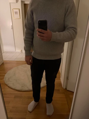 Maison Margiela stickad tröja S  - Säljer en stilren grå stickad tröja från Maison Margiela. Tröjan har rund hals, ribbade muddar och är långärmad. Materialet är mjukt och ger en clean look, perfekt till jeans eller chinos. Diskret logotyp i nacken. Passformen är normal. Jättebra skick 10/10. Kan diskutera om priset!
