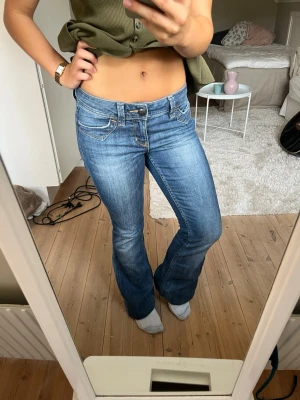 Blå bootcut jeans från Esprit - Säljer ett par snygga blå bootcut jeans från Esprit. De har låg midja, klassisk femficksdesign och är gjorda i jeansmaterial. Färgen är mellanblå med lätt slitning för en cool look. 