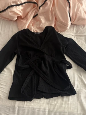 Svart blus från missäy - Jätte fin blus som inte är använd nån gång. Köpte nyss men tyckte inte den passade på mig. Den är lagom urringad och har ett knyte som man knyter i ryggen.