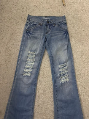 jeans  - säljer dessa lowaist bootcut jeans med slitningar  i strl 34. Midjemåttet är 32,5 cm. De kan ha en liten problem i gylfen med det går enkelt att fixa