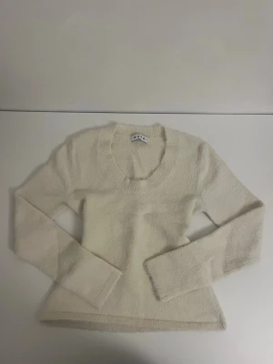 Uringad stickad tröja - Helt ny utringad fluffig stickad tröja från Åhléns, Wera. Tröjan har en åtsittande passform. 