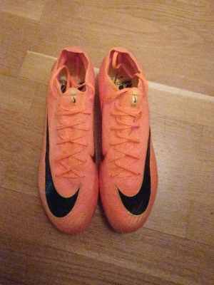 Nike orange fotbollsskor strl 44 - Säljer dessa skor då de inte riktigt passar mig. Köpta på unisport, nike mercurial vapor "deja vu", storlek 44. Originalkartong och påse medföljer. Använd 1 gång så de är typ fortfarande sprillans nya. 