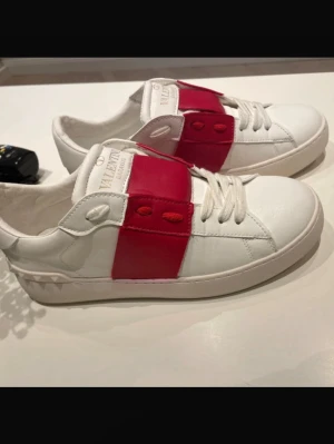 Valentino Open sneakers vit/röd - Jag säljer dessa fina Valentino-skor. De köptes från vinted och kom varken med kvitto eller originalkartong, men de är äkta. Lägg ett bud!