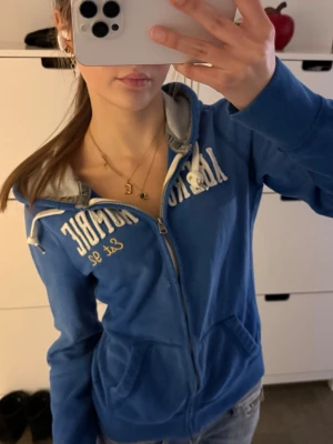 vintage Abercrombie & fitch zip up hoodie  - Vintage blå Abercrombie & Fitch huvtröja med dragkedja Storlek L men passar en S bättre eftersom den är slimfit! Mycket bra skick, förutom några små tecken på användning som syns på sista bilden! Har den vita Abercrombie & Fitch-logotypen över bröstet. Följ för fler liknande kläder och köp ett paket!