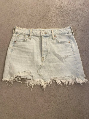 Ljusblå jeanskjol - Säljer en ljusblå jeanskjol från hm med fransad och sliten nederkant. 