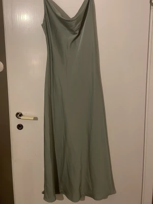 Silkes klänning - En helt oanvänd klänning i mint grön. Den är glansig och gjort i silkes. Fram till har den extra tyg som blir en fin detalj. Den är från Shien i storlek M