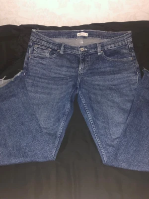Blå low waisted bootcut jeans från Gina Tricot - Säljer ett par blå low waisted bootcut jeans från Gina Tricot i storlek 44. Jeansen har klassisk femficksdesign och snygga kontrastsömmar på bakfickorna. Jeansen är klippta längst ner eftersom de var lite för långa, innerbens längden är 76cm. Jeansen är använda cirka 2 gånger. Meddela mig gärna vid frågor, priset kan diskuteras! 💗