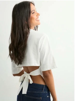 Vit croppad topp med knyt från Nelly - Säljer en vit croppad topp från Nelly i storlek XS. Toppen har korta ärmar och en öppen rygg med breda band som knyts i en rosett bak. Perfekt för dig som gillar trendiga och stilrena plagg med snygga detaljer.