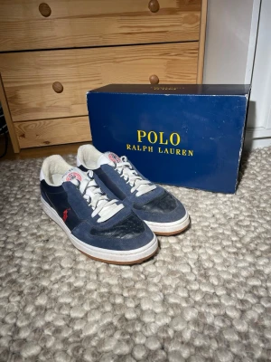 Polo Ralph Lauren Court sneakers - Säljer ett par marinblå sneakers från Polo Ralph Lauren. Använda väldigt lite. Skick 9,5/10 nästan helt nya. Låda fås med. Storlek 41. Perfekt nu när våren är runt hörnet!