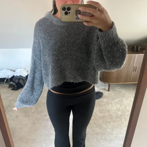Grå  stickad tröja - Supermjuk och fluffig grå stickad tröja med croppad passform och långa ärmar. Tröjan har en avslappnad, loose fit och är riktigt mysig att bära under kyliga dagar. Storlek XS/S från arket 