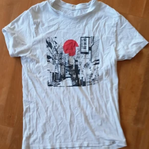 T-shirt med tryck - T-shirt med japanskt tryck och skrift. 100% bonull och hög kvalités tryck. Litet hål på framsidan, nån halv cm. Köptes i spanien nåt år tillbaks