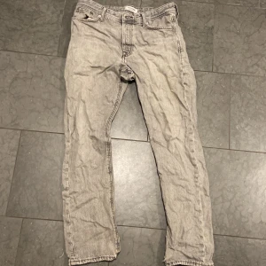 Grå loose fit jeans Jack & Jones - Grå jeans från Jack & Jones i loose fit-modellen Chris. Jeansen har klassisk femficksdesign, raka ben och är tillverkade i bomull. Perfekt för dig som gillar en avslappnad och bekväm stil.