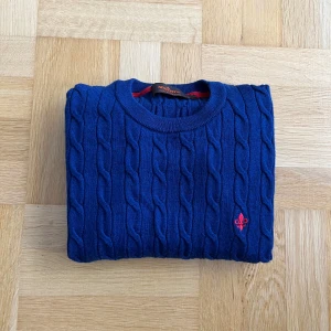 Blå kabelstickad tröja från Morris i Merinoull - Riktigt fin Morris kabelstickad tröja i merinoull samt färgen mörkblå och storlek S. Tröjan har inga skavanker eller liknande och är i mycket bra skick. Säljer då den inte passar. Vid frågor eller funderingar är det bara att höra av sig!