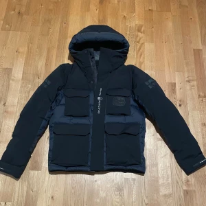 Svart/mörkblå Sail Racing glacier jacket Gore-Tex - Säljer en mycket fin sail racing jacka. Jackan är Gore-Tex vilket gör den vattentät. Den är perfekt för kalla vintern men kan också funka bra för hösten. Jackan har inte använt mycket alls men har ett mycket litet hål på högra fickan. Ordpris: 8000.                                                                         Säljs för: 4700