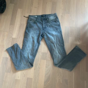 Jack and Jones slim fit Glenn  - Säljer ett par grå jeans från Jack & Jones i modellen Slim Glenn. Jeansen har klassisk femficksdesign, normal midja och raka ben. Materialet är mjukt denim i bomull med en snygg tvättad look. Perfekta för dig som gillar en stilren och enkel vibe.