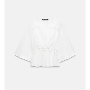 Vit blus med v-ringning från Zara - Säljer en luftig vit blus från Zara med v-ringning och vida trekvartsärmar. Blusen har dekorativa knappar framtill och fina spetsdetaljer längs midjan och bröstet. Perfekt för dig som gillar romantisk och bohemisk stil. Aldrig använts men tyvärr prislappen borta!