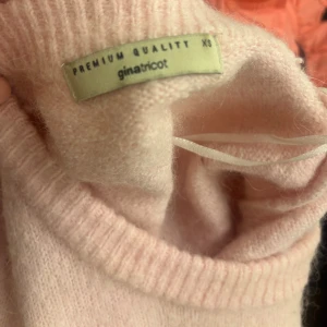 Ljusrosa stickad tröja Gina Tricot XS - Supermjuk ljusrosa stickad tröja från Gina Tricot i kortärmad modell. Tröjan har rund halsringning och ribbade kanter, perfekt för lager-på-lager eller som den är. Enkel och stilren design som är lätt att matcha.