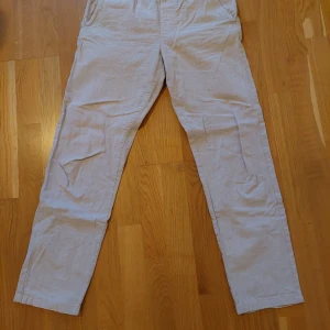 Beige linnebyxor från Selected Homme - Snygga beige linnebyxor från Selected Homme i modellen SLHSTRAIGHT-SILAS. Byxorna har raka ben, sidofickor och bakfickor. Perfekta för en chill och stilren look under varmare dagar. Materialet är 100% linne för en luftig känsla.