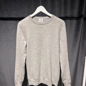 John Henric Kashmir - Säljer en klassisk ljusgrå stickad tröja från John Henric. Tröjan har rund halsringning och långa ärmar. Perfekt för lager-på-lager och enkel att matcha med olika outfits. Riktigt bra skick i storlek S. Skriv vid minsta fundering!