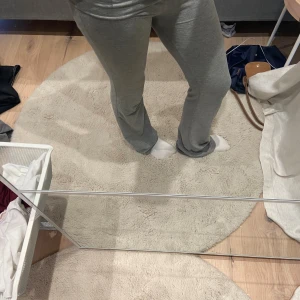 Grå mjukisbyxor från Gina Tricot - Grå mjukisbyxor från Gina Tricot med rak passform och bekväm midja. Byxorna är tillverkade i mjukt material och har en enkel, stilren look som passar perfekt för chill dagar. Snygga att matcha med en hoodie eller t-shirt.