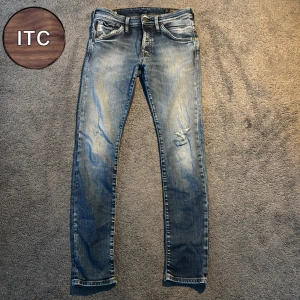 Blå jeans med slitningar - Snygga blå jeans med slitningar och lätt tvättad look. Klassisk femficksmodell med raka ben och normal passform. Perfekta för en avslappnad stil och passar till det mesta. Jeansen har en cool, lite sliten känsla och är gjorda i mjukt denimtyg.