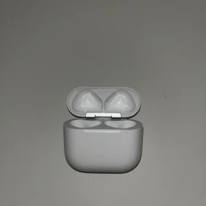 Apple AirPods Pro (laddningsetui) - Originalt laddningsetui till Apple AirPods Pro. Fodralet är vitt och har några mindre repor och tecken på normalt slitage, men är i gott skick. Perfekt som ersättning eller extra etui. USB-C laddningsport. Hörlurar ingår ej.