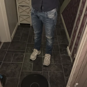 Replay Anbass ljusblå jeans, stl 30 - Säljer ett par Replay Anbass jeans i ljusblå tvätt med slitningar och snygga detaljer på fickorna. Jeansen har en slim passform och klassisk femficksdesign. Materialet är stretchigt jeans och de har dragkedja i gylfen. Perfekta för dig som gillar en modern look. För långa för mig som är 170 men funkar endå. L32