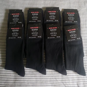 8 Par Svarta Herrstrumpor Stl 40 /45 - Helt nya. Finstickade strumpor i mjuk bomullsblandning, har högt skaft med resår, rök och djurfri hem, kan hämtas i Norra Stockholm. 