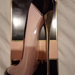 Stilren parfym i klackform 80ml - (Finns även 5 olika sorter)Parfym med unik klackformad flaska som sticker ut i badrumshyllan. Perfekt för dig som gillar trendiga detaljer och vill ha något annorlunda. Finns i olika färger. Märke: Carolina Herrera.