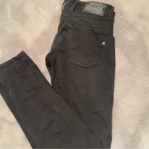Svarta Replay Anbass jeans - Snygga svarta slim fit jeans från Replay med klassisk femficksdesign och diskret Replay-logga på fickan. Jeansen har raka ben och är tillverkade i ett mjukt och stretchigt denimtyg som sitter tajt men bekvämt. Perfekta för dig som gillar en stilren look. Storlek 29/32 men passar även på mig som har 29/30 på andra jeans. Pris kan diskuteras vid snabb affär