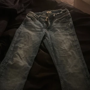 Blå jeans från Gina Tricot - Säljer ett par klassiska blå jeans från Gina Tricot i storlek L. Jeansen har en snygg tvättad look, fem fickor och raka ben. Perfekta för dig som gillar en enkel och stilren vibe. Materialet är mjukt och bekvämt jeans.