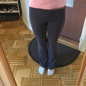 Mörkgrå bootcut leggings - Mörk grå leggings med bootcut-snitt och låg midja. Mjukt och stretchigt material som sitter skönt och följer kroppen. Perfekta för en avslappnad och trendig look.