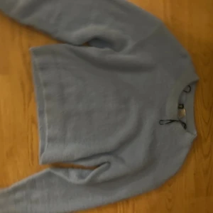 Ljusblå stickad tröja från Divided - Supermjuk ljusblå stickad tröja från Divided hm. Tröjan har en croppad passform, rund halsringning och långa ärmar. Perfekt för lager-på-lager och chill dagar. Enkel och stilren design som är lätt att matcha.