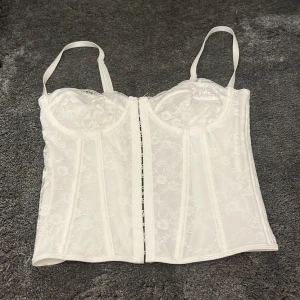 Vit spetskorsett med snörning  - jätte fin korsett tyvärr passa den inte mig. den är perfekt till helloween eller nån fest. jag hitta ingen lapp så vet inte var den är ifrån så säljer för 150kr. skriv för fler bilder 