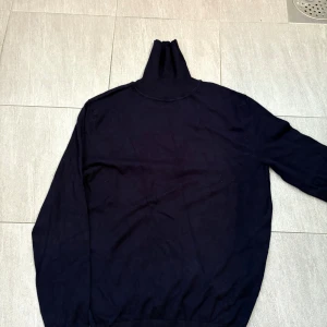 Svart polotröja från Dan John - Klassisk svart polotröja från Dan John med lång ärm och hög krage. Tröjan är tillverkad i en mjuk blandning av viskos och nylon, vilket gör den både bekväm och stilren. Perfekt för dig som vill klä dig elegant🌟 ny pris 500kr säljs nu för endast 199kr!