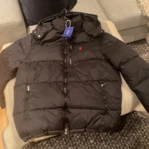 Polo Ralph Lauren puffjacka svart  - Svart pufferjacka från Polo Ralph Lauren. Säljer då jag inte vill ha den. Stilren är i stl L men skulle säga att den är liten i storleken så passar M också. Endast seriösa köpare och inga skambud. 