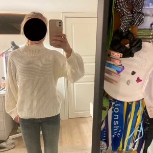 Vit stickad polotröja från Monki - Säljer en Stockholmsstil vit stickad polotröja från Monki i storlek XXS. Tröjan har en hög ribbad krage. Perfekt för lager-på-lager och chill höst- eller vinterstil. Köpte för ungefär 400-500kr. Väldigt säker på att den inte finns att köpa längre. Den sticks ingenting.