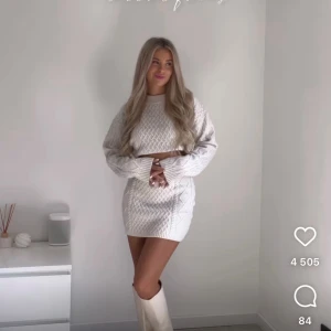 Vit croppad stickad tröja - Säljer en vit croppad stickad tröja med kabelstickat mönster. Tröjan har lång ärm och en snygg, lite oversized passform. Perfekt att matcha med kjol eller jeans för en trendig look.