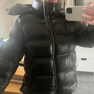 Mörkgrön pufferjacka med huva - Säljer min mörkgröna pufferjacka med glansig finish och stor mysig huva. Jackan är från Massimo Dutti och är som ny då den köptes förra året och bara använd ett fåtal gånger❤️Håller även värmen SÅ bra så perfekt till hösten/vintern! Pris kan diskuteras, skriv om du har några frågor!