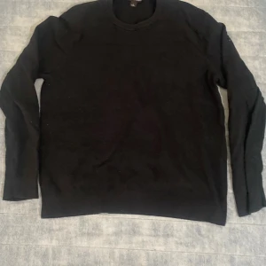 Svart Micheal Kors tjocktröja  - En klassisk svart stickad tröja med rund halsringning och långa ärmar. Perfekt att matcha med jeans eller kjol för en enkel och stilren look. Mjuk och skön, passar bra under kyligare dagar. Storlek L men skulle personligen säga att den passar som en M 