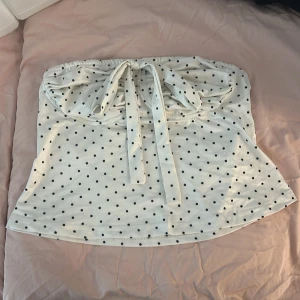 Vit prickig topp med knyt - Säljer en supersöt prickig topp då den är lite liten för mig. 