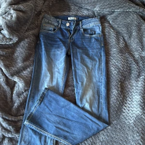 Blå jeans från Raizzed - Snygga blå bootcut Jeans i storlek 152 dom är low waist . Jeansen har normal passform omed lätt slitning framtill och bakfickor med enkel söm.och går inte att hitta i butiker längre