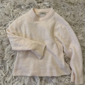 Ljusbeige stickad tröja Gina Tricot - Supermysig ljusbeige stickad tröja från Gina Tricot med rund halsringning och ribbade muddar. Perfekt för lager-på-lager och chill dagar. Enkel och stilren design som funkar till allt.