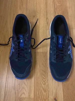 Blåa inne skor från asics - Blåa inne skor från asics som köptes för 800kr. Skorna är som nya och har bara använts ett par gånger. Gör gärna av dig om du är intresserad!!