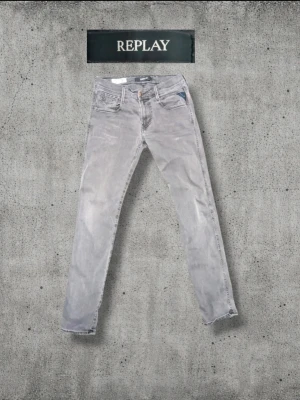 Gråa Replay jeans med smal passform - Säljer ett par gråa jeans från Replay med smal passform och klassisk femficksdesign. Jeansen har snygga detaljer på bakfickorna och är tillverkade i mjukt denimtyg. Perfekta för dig som gillar en stilren och avslappnad look.