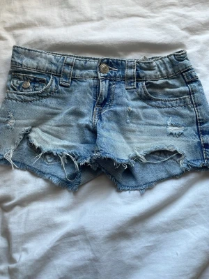 Blå jeansshorts - Snygga ljusblå jeansshorts med slitna ditaliger. Perfekta för sommaren , och säljs på grund av att de är för små❤️
