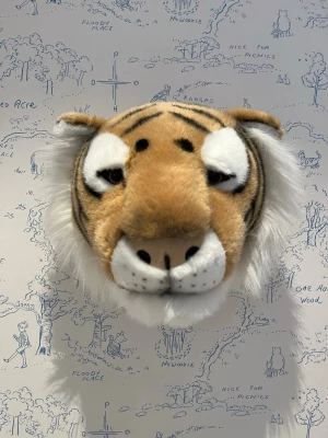Väggdekoration Tigerhuvud från Brigbys - Cool väggdekoration i form av ett tigerhuvud i mjuk polyester. Huvudet är brunt med svarta ränder, vita detaljer runt ögon och nos samt fluffig vit man. Perfekt som inredningsdetalj för att ge rummet en unik och lekfull känsla.