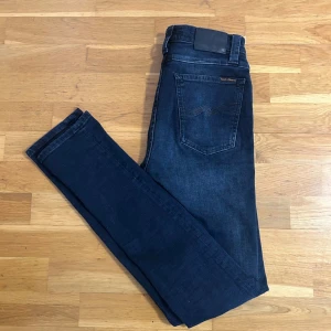 Nudie jeans Grim tim - Nudie jeans W28 L32, marinblå/svart, snygg passform grim tim . Bra kvalitet och i fint skick. Priset kan diskuteras!